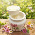 Vela artesanal en resina acrílica blanca con flores rosas - fondo natural